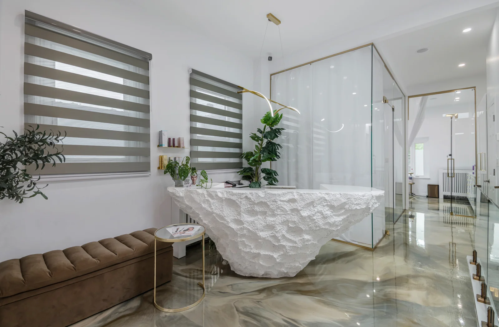 Activate Beauty reception — sculptural stone desk, glass treatment room and marble floor, Toronto